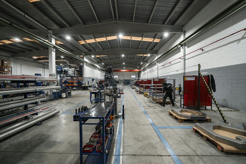 Workers moving through a large factory floor with machinery